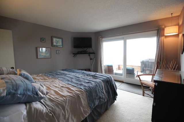 carpeted bedroom featuring access to outside and a textured ceiling