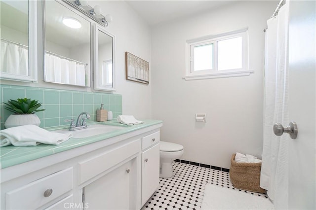 bathroom featuring decorative backsplash, vanity, and toilet