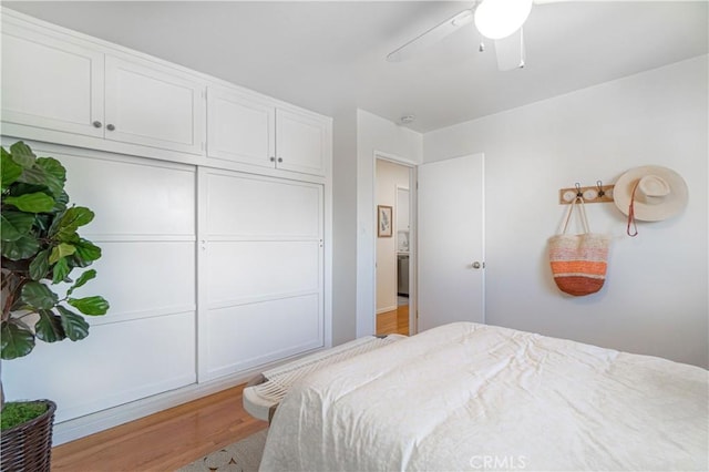 bedroom featuring ceiling fan, light wood-type flooring, and a closet