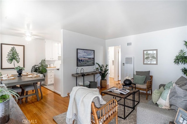 living room with ceiling fan and light wood-type flooring