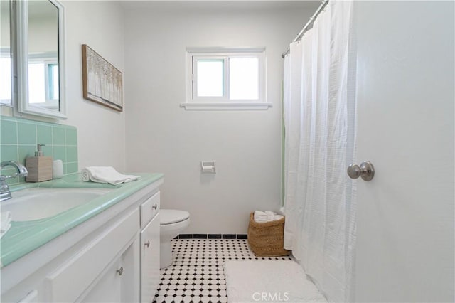 bathroom with backsplash, vanity, and toilet