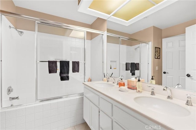 bathroom with tile patterned floors, vanity, and combined bath / shower with glass door