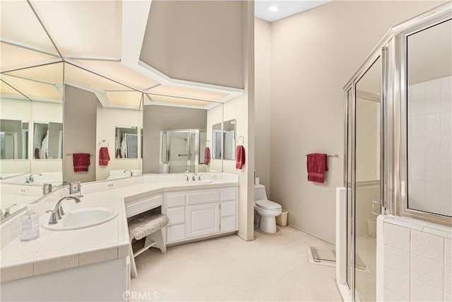 bathroom with toilet, vanity, and a shower with shower door