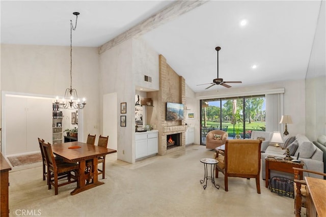 dining area with high vaulted ceiling, a fireplace, ceiling fan with notable chandelier, and light carpet