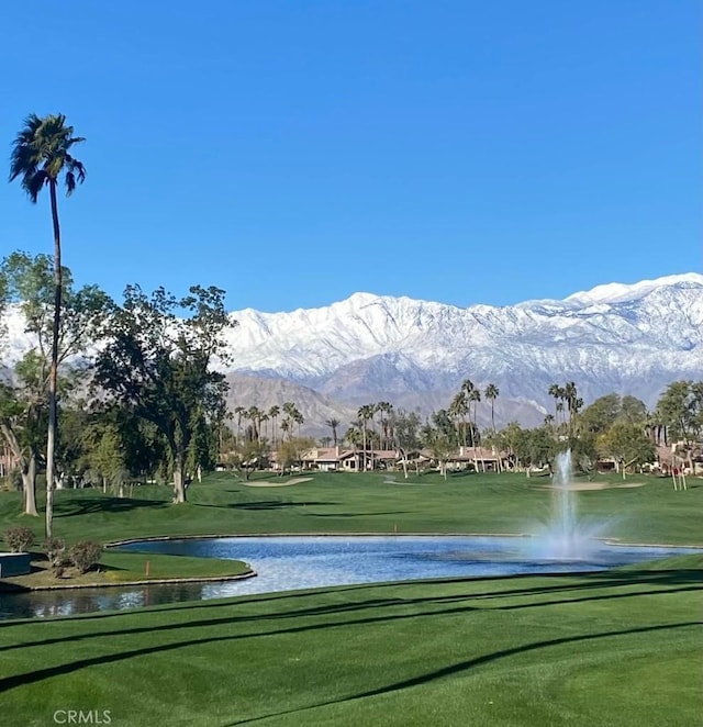 view of home's community with a water and mountain view and a yard