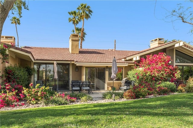 rear view of house with a yard and a patio area