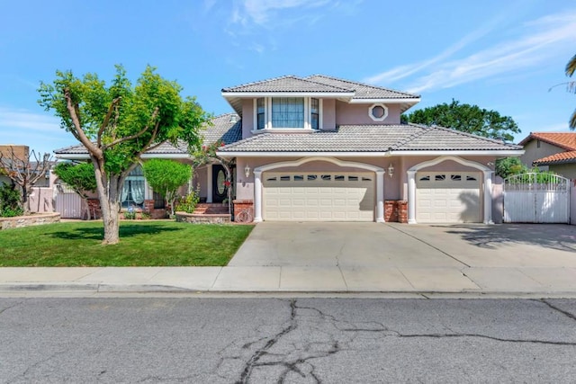 mediterranean / spanish home with a garage and a front lawn