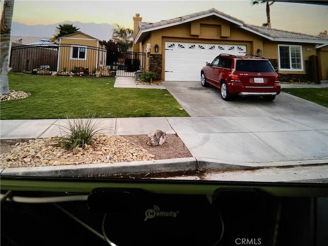 view of front of home with a garage and a yard