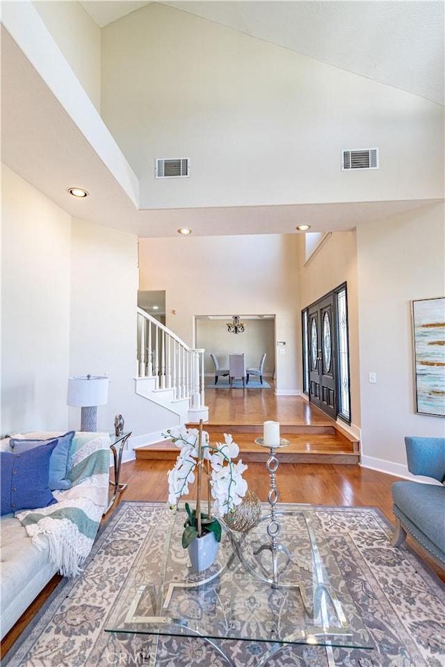 living room featuring wood-type flooring and high vaulted ceiling