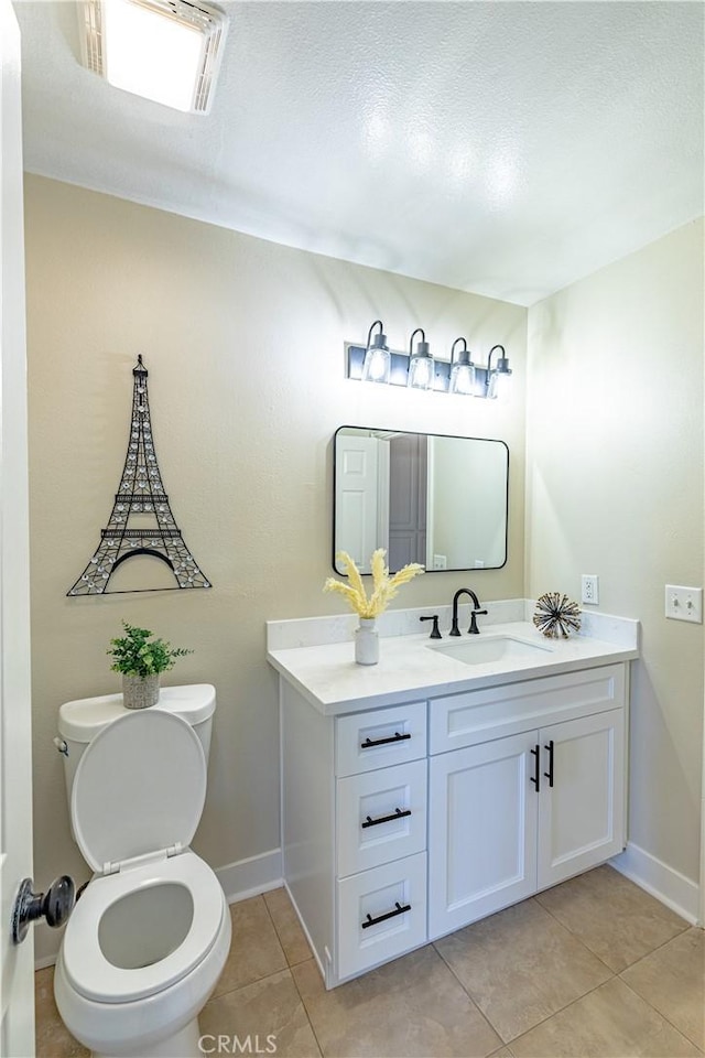 bathroom featuring tile patterned flooring, vanity, and toilet