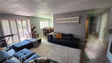 living room with wood-type flooring and a textured ceiling