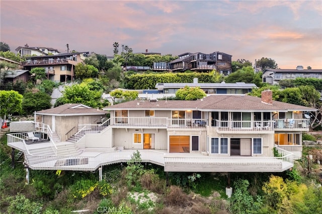 back house at dusk with a balcony