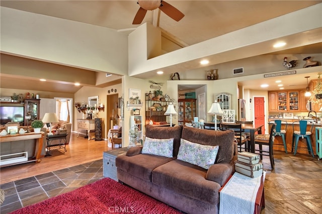 living room with ceiling fan, sink, high vaulted ceiling, and dark wood-type flooring