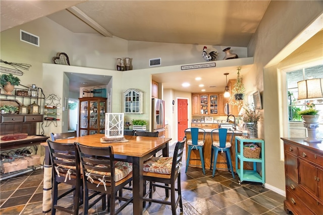 dining space with lofted ceiling and sink