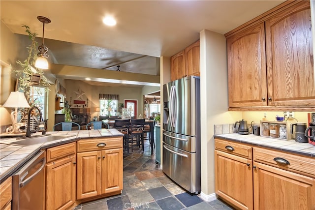 kitchen with tile countertops, sink, and stainless steel appliances