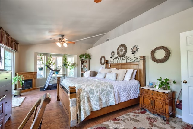 bedroom with ceiling fan, wood-type flooring, and vaulted ceiling