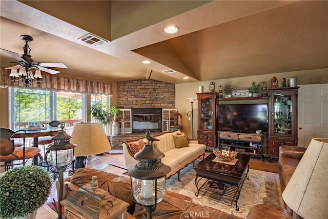 living room with a textured ceiling, ceiling fan, a fireplace, and lofted ceiling