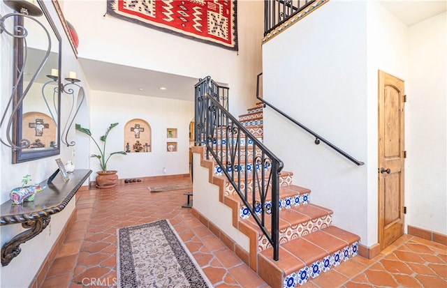 staircase with a high ceiling and tile floors