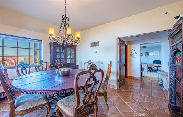 tiled dining room with an inviting chandelier