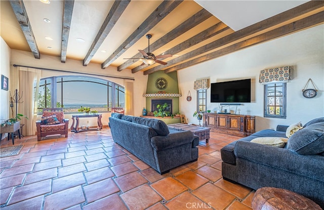 living room with tile floors, beam ceiling, ceiling fan, and a fireplace