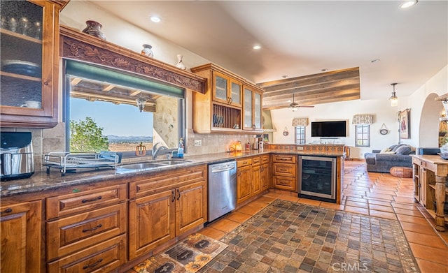 kitchen with ceiling fan, dishwasher, beverage cooler, tasteful backsplash, and sink