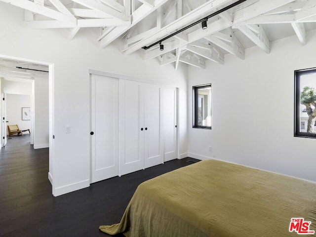 bedroom with lofted ceiling with beams, dark hardwood / wood-style floors, and ceiling fan