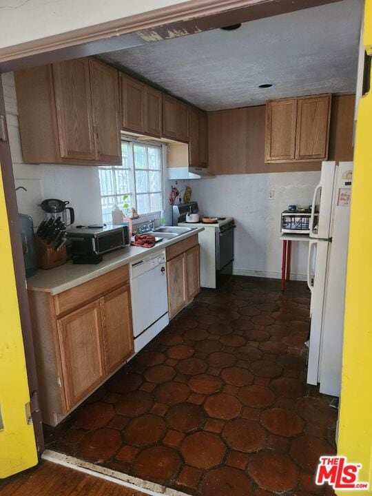 kitchen with sink, white appliances, and dark wood-type flooring