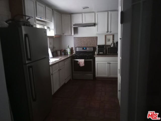 kitchen featuring dark tile floors, stainless steel stove, and black refrigerator