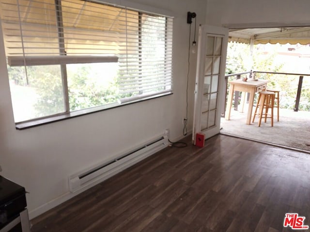 interior space featuring a baseboard heating unit and dark wood-type flooring