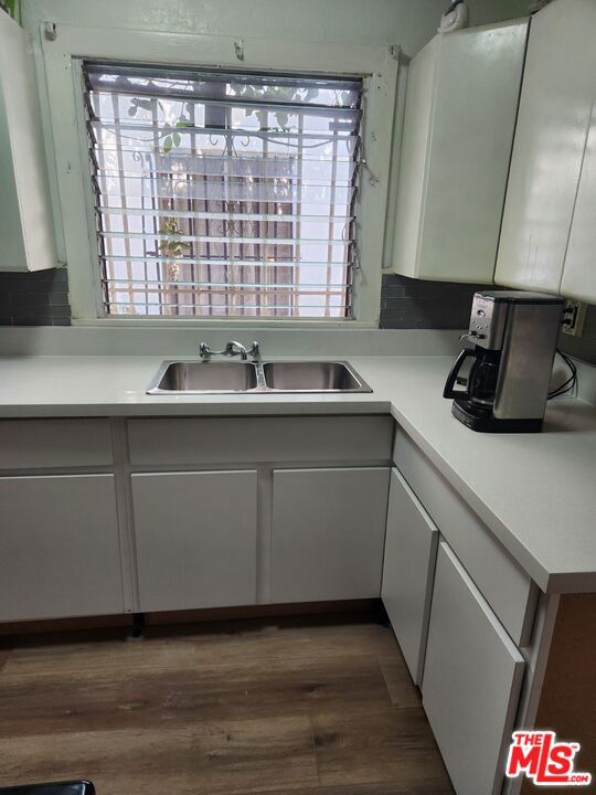 kitchen featuring a healthy amount of sunlight, sink, and hardwood / wood-style flooring