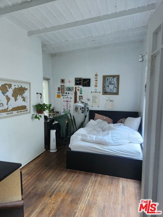 bedroom featuring beamed ceiling and hardwood / wood-style flooring