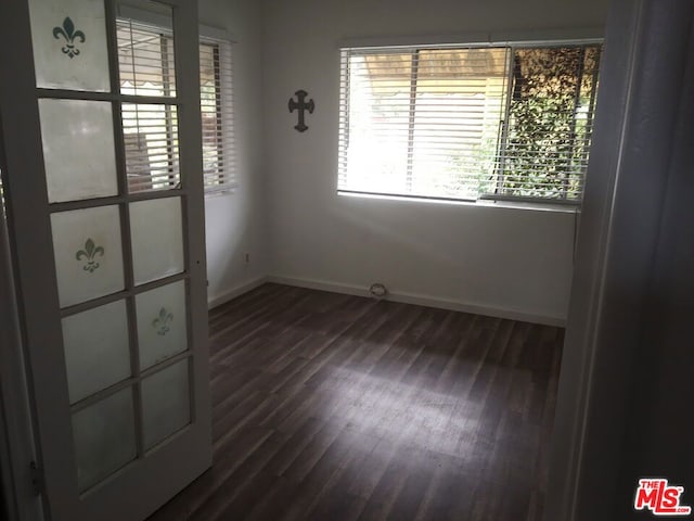 unfurnished room with dark hardwood / wood-style flooring