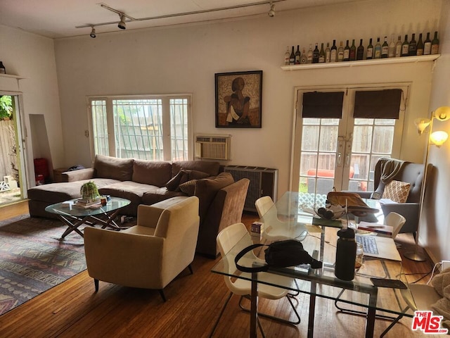 living room with a wall unit AC, french doors, hardwood / wood-style floors, and rail lighting