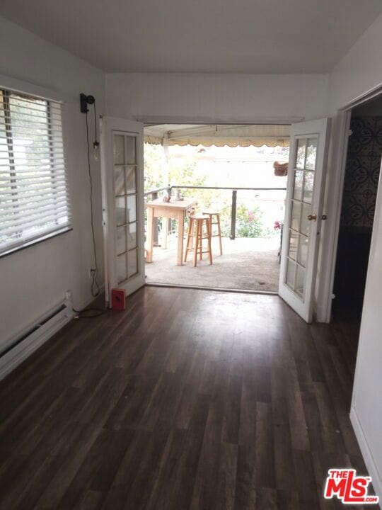 spare room featuring dark hardwood / wood-style floors and french doors