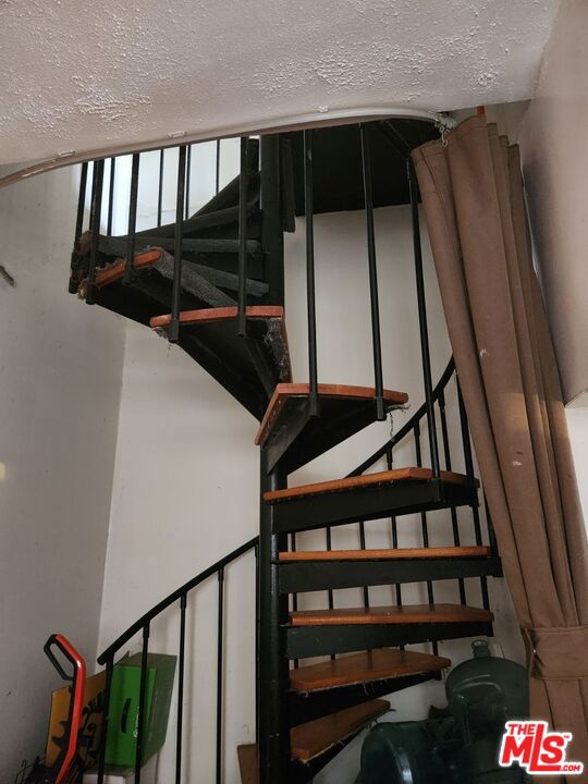 stairway featuring a textured ceiling