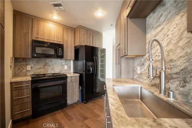 kitchen featuring sink, backsplash, dark wood-type flooring, and black appliances