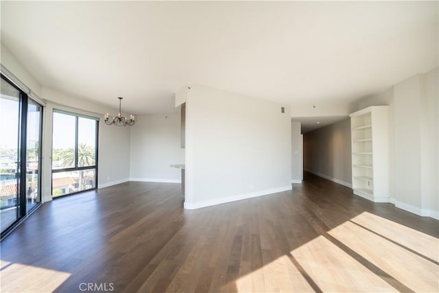 empty room featuring dark hardwood / wood-style floors and an inviting chandelier