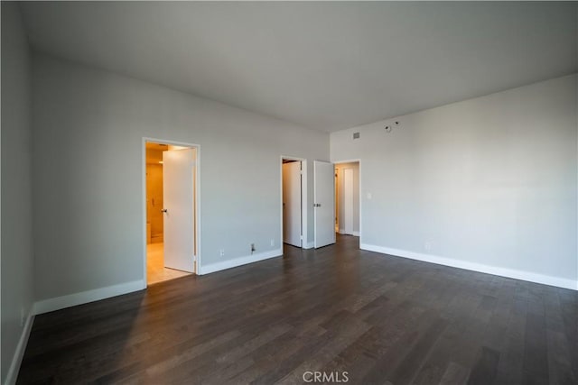 unfurnished bedroom with connected bathroom and dark hardwood / wood-style flooring