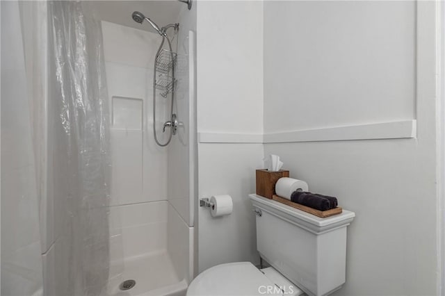 bathroom with toilet and a shower with shower curtain