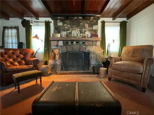 living area featuring wood ceiling, a stone fireplace, a healthy amount of sunlight, and beam ceiling