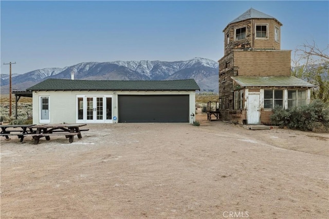 exterior space featuring a mountain view, french doors, and a garage