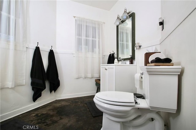 bathroom featuring vanity, concrete floors, and toilet