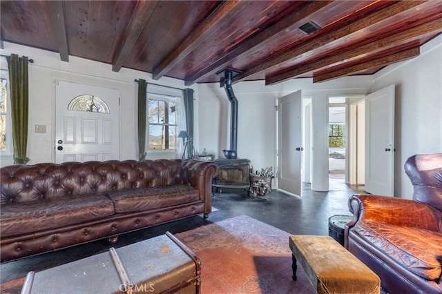 living room with beam ceiling and a wood stove