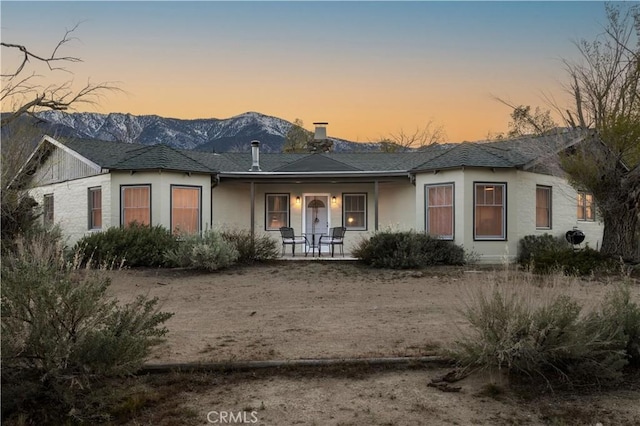 back house at dusk featuring a mountain view