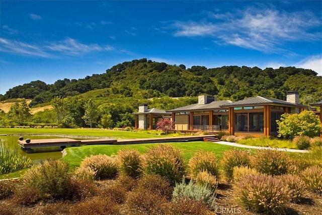 back of property with a lawn and a sunroom