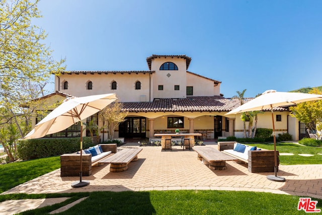 rear view of house featuring a lawn, an outdoor living space, and a patio