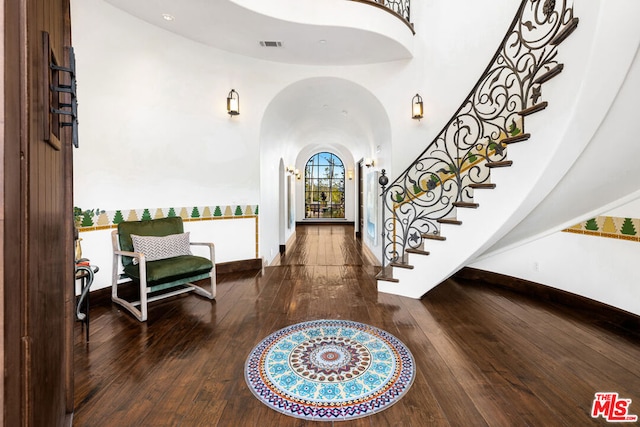 foyer with a high ceiling and hardwood / wood-style floors