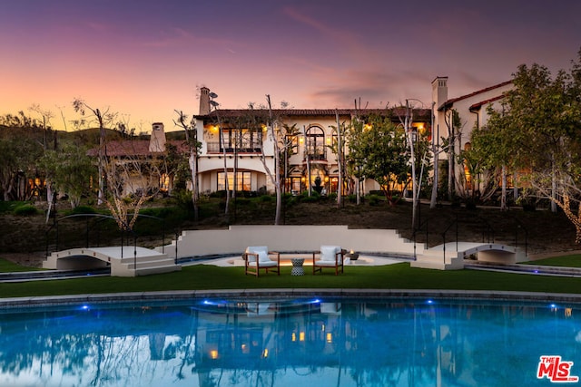 pool at dusk with a lawn