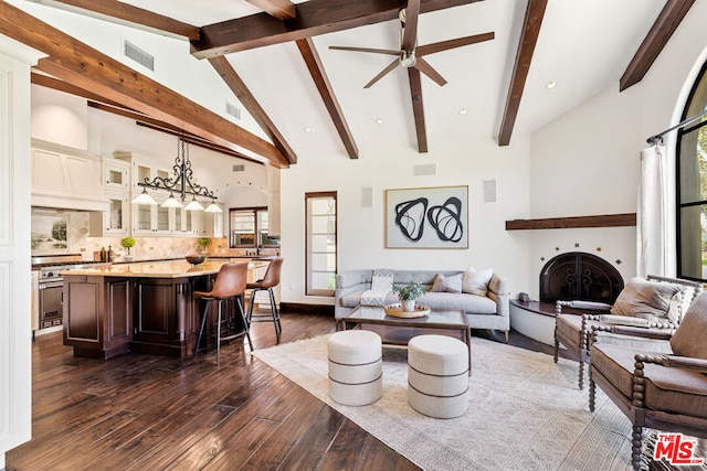 living room with ceiling fan, dark hardwood / wood-style floors, high vaulted ceiling, and beam ceiling