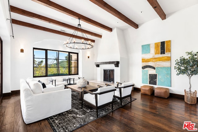 living room with a large fireplace, beamed ceiling, dark hardwood / wood-style flooring, and a chandelier